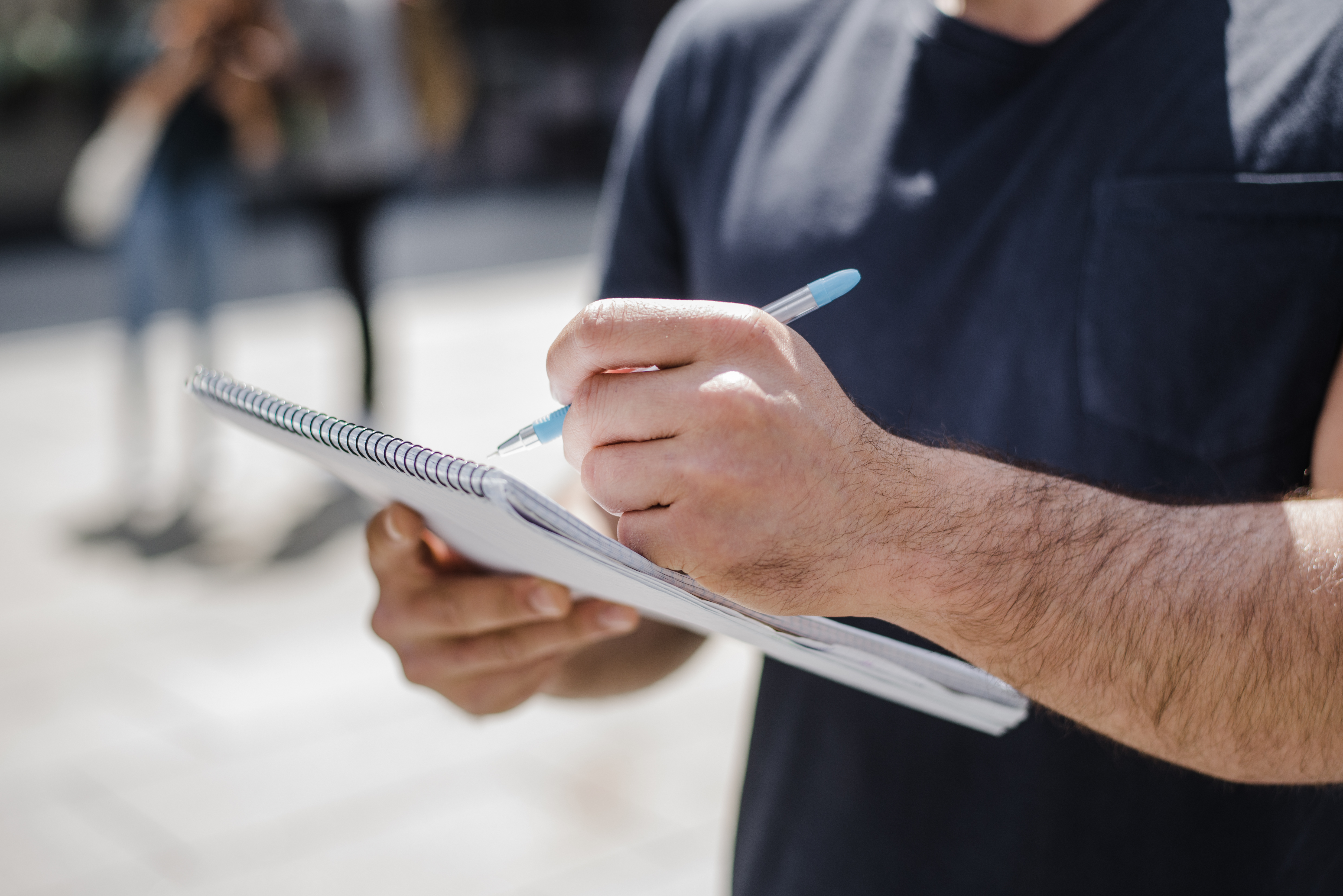 Un homme écrit dans un carnet avec un stylo